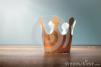 Cardboard golden crown on wood table with morining light. Stock Photo