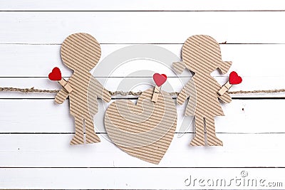 Cardboard silhouettes girl and boy with heart on white wooden ba Stock Photo