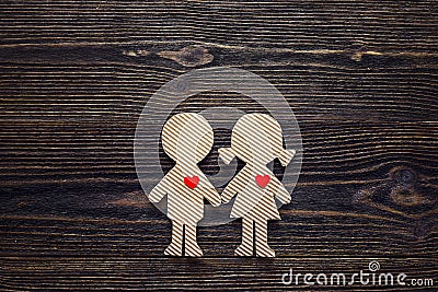 Cardboard silhouettes girl and boy with hearts on a wooden table Stock Photo