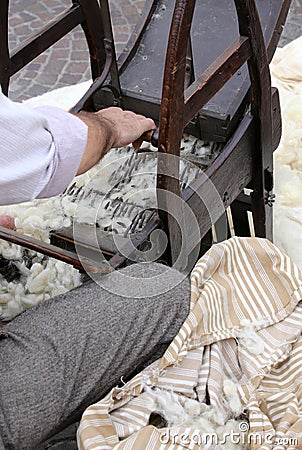 carder while carding with wooden machine to make the mattresses Stock Photo