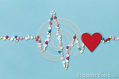 Cardiogram is made of colorful drug pills and red paper heart, pharmaceutical and cardiology concept Stock Photo