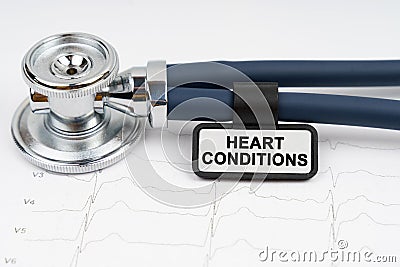 On the cardiogram is a stethoscope and a plate with the inscription - HEART CONDITIONS Stock Photo