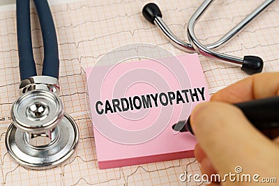 On the cardiograms there is a stethoscope and a sticker with the inscription - cardiomyopathy Stock Photo