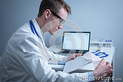 Cardiologist reading an ECG print-out. Doctor analyzing electrocardiogram. Practitioner examine patient test results Stock Photo