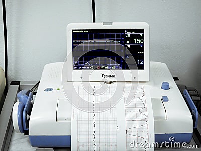 Cardiotocography device placed on mother's abdomen recording the fetal heart rate obtained via ultrasound transducer Stock Photo