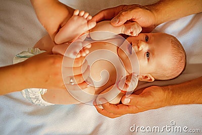 Because care begins in family. Newborn baby given massage by parents. Newborn baby care. Happy parenting. Parenting is Stock Photo