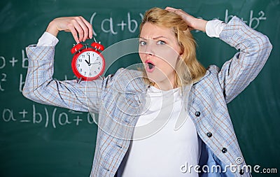 She care about discipline. Woman teacher hold alarm clock. Lessons schedule concept. Time for break. Girl wonder about Stock Photo
