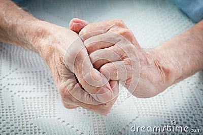 Care is at home of elderly. Old people holding hands. Stock Photo
