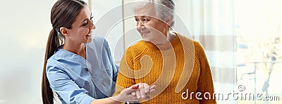 Care worker helping elderly woman to walk in geriatric hospice Stock Photo