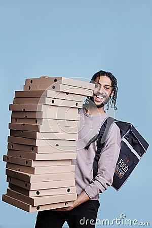 Carefree arab deliveryman carrying big pizza boxes pile Stock Photo