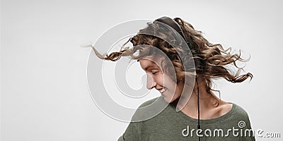 Carefree cheerful young curly woman listen favourite music Stock Photo