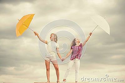 Carefree children outdoors. Freedom and freshness. Weather forecast. Weather changing. Girls friends with umbrellas Stock Photo