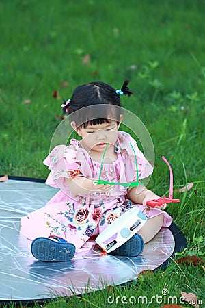 Carefree Chinese baby girl play on the lawn Stock Photo