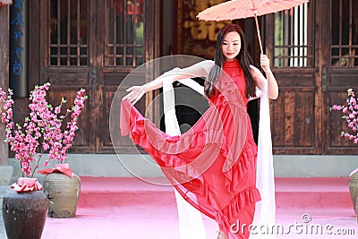 Carefree Chinese beauty is dancing in red dress Stock Photo