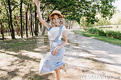 Carefree european girl in blue attire dancing in park. Outdoor portrait of blithesome young woman i Stock Photo