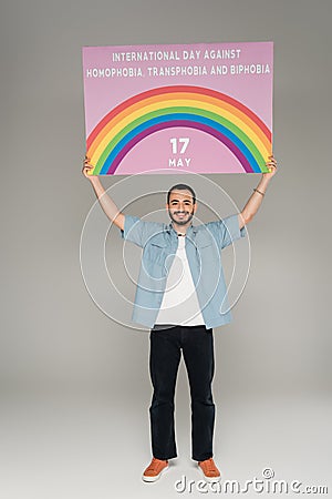 Carefree gay man holding placard with Stock Photo