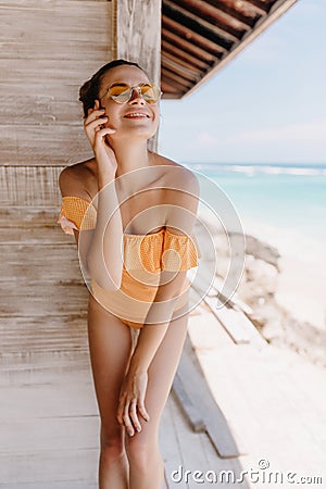 Carefree girl posing at beach with eyes closed and sincere smile. Outdoor shot of magnificent slim Stock Photo