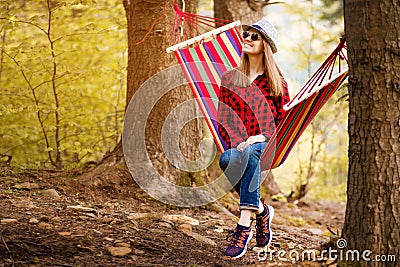 Carefree happy woman lying on hammock enjoying harmony with nature. Freedom. Enjoyment. Relaxing in forest. Stock Photo