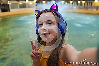 Schoolgirl preteen resting at dusk by fountain Stock Photo