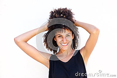 Carefree smiling woman standing with hands in curly hair Stock Photo