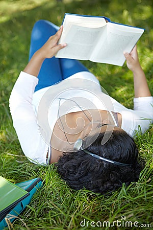Carefree Student Revising And Listening To Music In Park Stock Photo