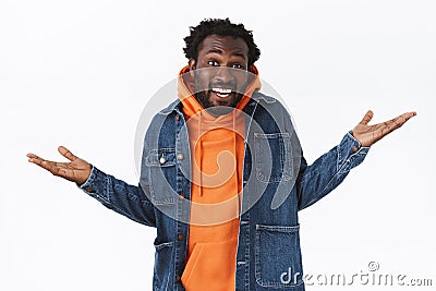 Carefree unbothered cool stylish african-american bearded man, spread hands sideways relaxed and chill, smiling shaking Stock Photo