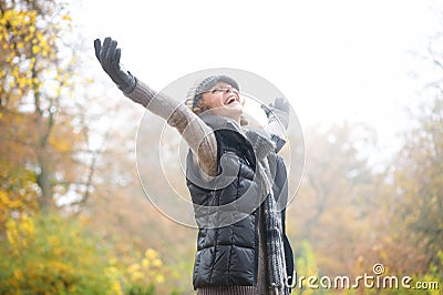Carefree Woman with Outstreched Arms in Autumn Stock Photo