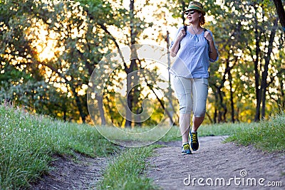 Carefree Woman walking on Forest Trail at Sunset Stock Photo