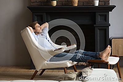 Carefree young male resting in capacious armchair at luxury apartment Stock Photo