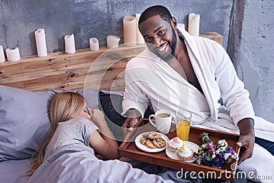 Careful African American man waking girlfriend in the bedroom Stock Photo