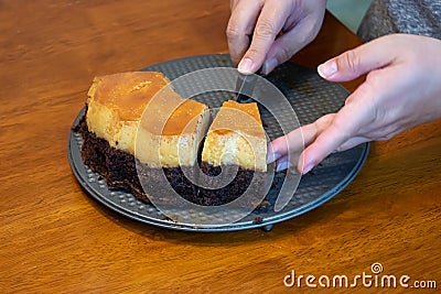 Careful hands cutting into a chocolate cake Stock Photo