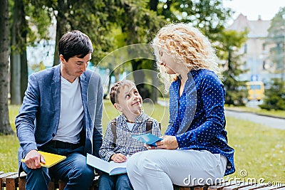 Careful mature parents helping child to learn new things. Stock Photo