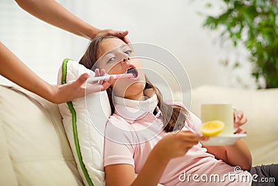 Careful mother giving medicinal syrup to her daughter Stock Photo