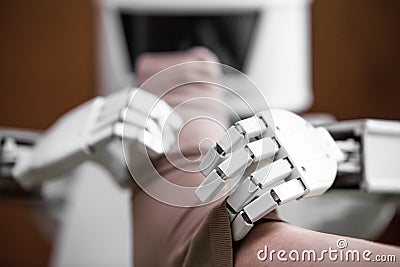 Caregiver robot or medical assisted living robot is putting on a compression stocking Stock Photo