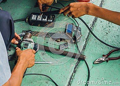 Careless worker use hand grinding without safety gloves, outlet generating electricity sparks Stock Photo