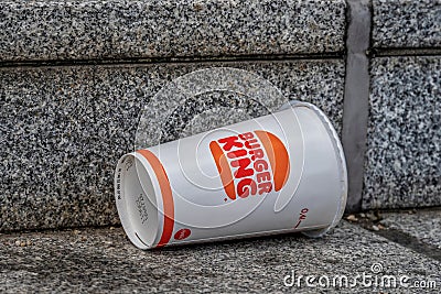 Carelessly discarded one-way drinking cup from a fast food chain on a staircase Editorial Stock Photo