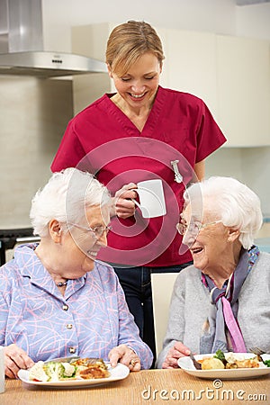 Carer drinking tea with two elderly woman Stock Photo