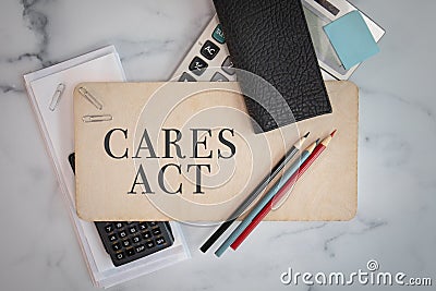 CARES ACT wooden sign office business supplies pencils calculators flat lay background Stock Photo