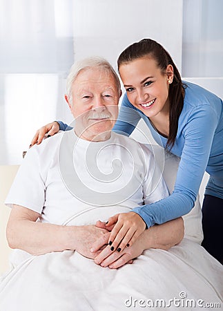 Caretaker with senior man at nursing home Stock Photo