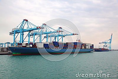 Cargo boat and barge docked to industrial port Stock Photo