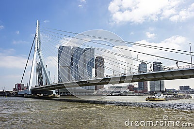 A cargo boat is just passing the erasmus bridge in Rotterdam Editorial Stock Photo