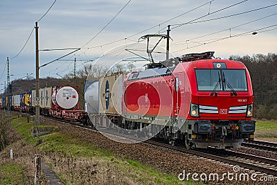 Cargo class locomotive with colorful wagons passing through Saarmund, Germany Editorial Stock Photo