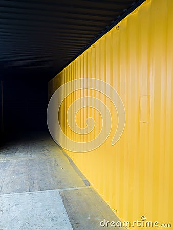 Cargo container deep to the dark with yellow wall Stock Photo