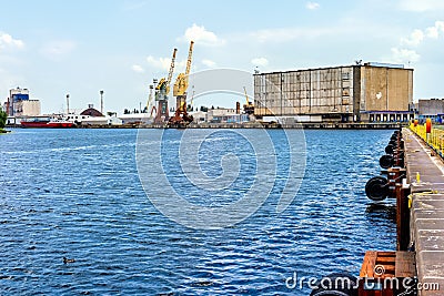 Cargo port and harbour in Szczecin with cargo ship, dock cranes and industrial machinery Stock Photo