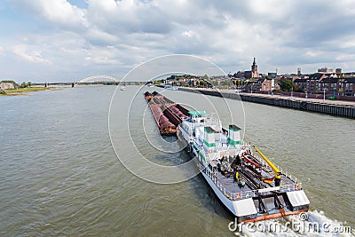 Cargo riverboat passing the Dutch city Nijmegen Stock Photo