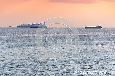 Cargo ships and barge at beautiful sunset. Amazing evening seascape, breathtaking travel view, copy space. Anchorage for ships Editorial Stock Photo