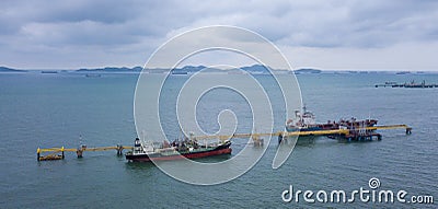 Cargo tanker ship marine vessel docking and oversea berth mooring platform for petroleum and crude oil industry from aerial view Stock Photo