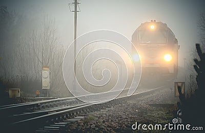 Cargo train emerging from the mist Stock Photo