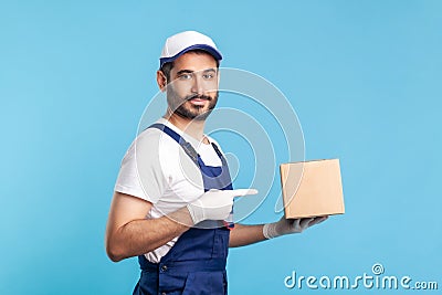 Cargo transportation, delivery service. Side view, worker in uniform pointing at cardboard box Stock Photo