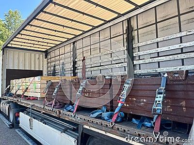 Cargo transportation of screws in wooden and metal boxes in a semi-trailer truck. Side loading of bolts Editorial Stock Photo